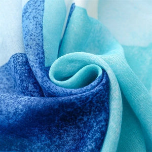 Macro detail of lightweight scarf fabric with blue gradient patterns and soft woven texture