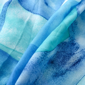 Macro detail of abstract blue watercolor pattern and breathable linen texture on a scarf
