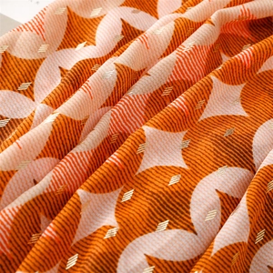 Detailed view of the geometric star pattern and golden metallic thread on the cotton scarf