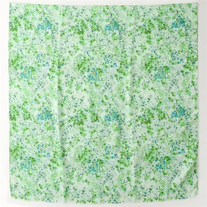 Détail d'un foulard floral vert clair montrant la texture en coton lin et les bordures