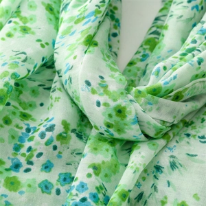 Détail du foulard à fleurs vert clair avec une texture douce au toucher coton et lin