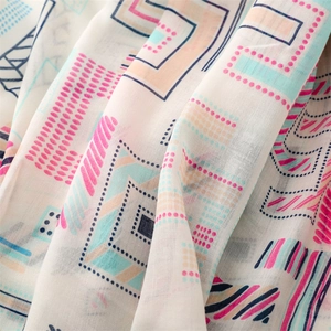 Detailed macro view showing the light cotton-linen texture and colorful geometric patterns