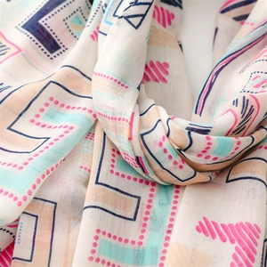 Close-up of lightweight geometric print scarf with pastel pink and mint textures