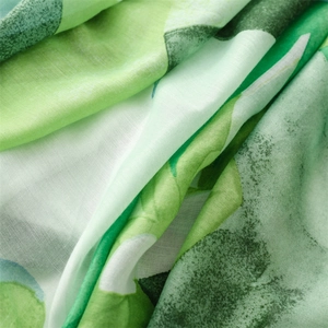 Close-up of lightweight cotton linen scarf with green plant print and soft texture