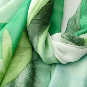 Macro detail of lightweight green leaf pattern scarf showing delicate fabric texture