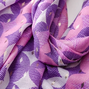 Detail of cotton linen scarf with geometric gold foil prints and bohemian tassel edge