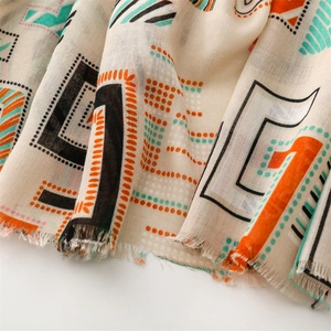 Detailed view of lightweight linen scarf featuring geometric patterns and fringed edges