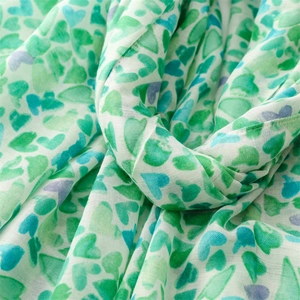 Détail d'une écharpe en coton-lin doux avec des motifs imprimés de cœurs colorés
