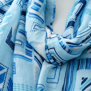 Close-up of blue linen scarf with geometric lines and dots showing soft fabric texture