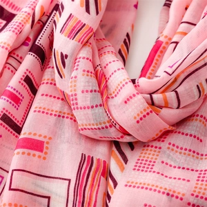 Detail view of pink cotton linen scarf featuring colorful geometric patterns and soft texture