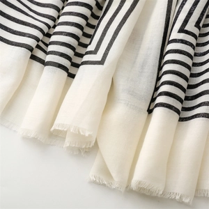 Detail showing the cotton-linen texture and black geometric stripes with frayed edges