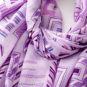 Macro detail of geometric print scarf showing fine linen texture and purple patterns