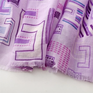 Detail of light purple scarf with geometric prints and delicate fringe edge texture