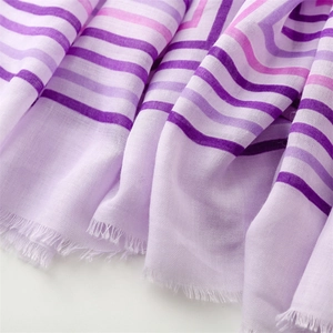 Detail of lavender cotton-linen scarf featuring purple stripes and frayed tassel edges