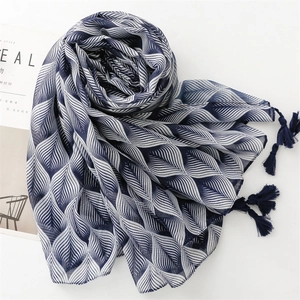 Elegant navy blue geometric leaf scarf with delicate tassels shown at a 45-degree angle