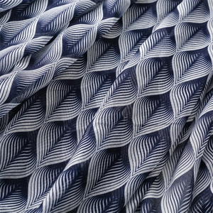 Detail of navy blue lightweight fabric with white leaf prints and soft elegant drapes