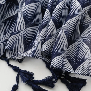 Detail of leaf pattern scarf with dark blue tassels and light breathable fabric