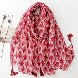 Red and white leaf print scarf with tassels styled on a minimalist background
