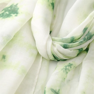 Détail d'une écharpe tie-dye vert clair avec texture plissée douce et effet peinture