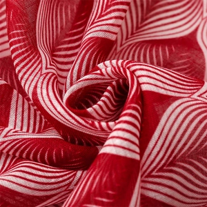 Detailed macro view of red and white leaf pattern on lightweight voile scarf fabric