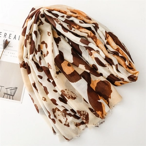 Macro detail of leopard print scarf with soft fringe edges and lightweight texture