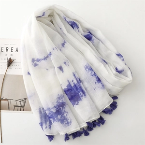 Vue détaillée d'une écharpe tie-dye avec glands violets sur un fond minimaliste