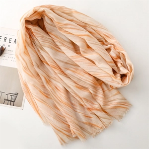 Detail of coral and beige marble wave pattern scarf with delicate fringe edges
