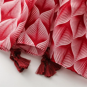 Detailed texture of red and white leaf pattern scarf with fine tassel edge