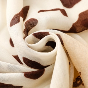 Close-up of lightweight leopard print scarf showing soft cotton texture and frayed edges