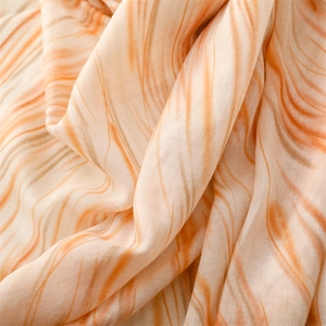 Macro detail of soft cotton-linen scarf with orange and beige fluid marble pattern