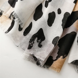 Close-up of cow print scarf showing premium cotton-linen texture and frayed fringe edges