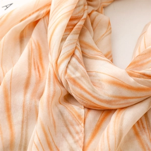 Macro view showing abstract marble pattern and soft texture on orange linen-feel scarf