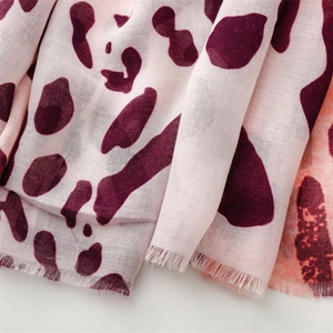 Close-up of leopard print scarf fabric with soft pink base and purple pattern fringe