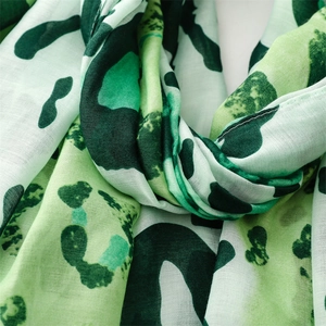 Macro shot of green leopard print scarf showing fine cotton linen texture and weave detail