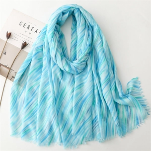 Detail of light blue and green striped scarf with soft fringe edges and linen feel