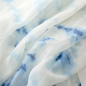 Détail du foulard dégradé bleu et blanc montrant la texture en lin respirant