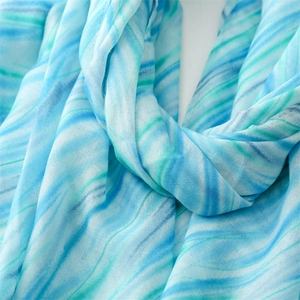 Detailed view of lightweight blue and green marble pattern scarf with soft draping fabric