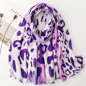 Detail of purple leopard print scarf with fine eyelash fringe on white surface