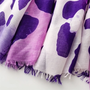 Detail of purple leopard animal print scarf showing woven texture and frayed tassel edges