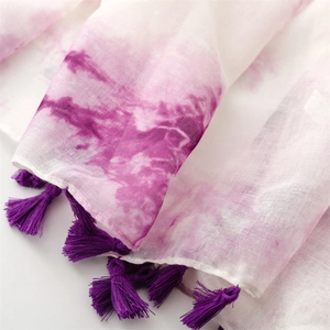 Détail de l'écharpe dégradée violette avec bordures en pompons faites à la main