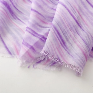 Detailed shot of purple tie-dye scarf fabric with elegant frayed edges and cotton texture