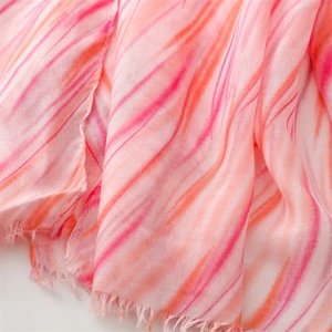 Detailed shot of pink and orange striped cotton linen scarf with soft fringe edges