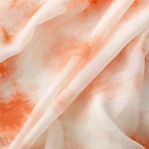 Vue détaillée du tissu tie-dye dégradé orange et blanc avec texture tissée fine