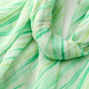 Detailed macro view of soft green striped linen-feel fabric texture and elegant draping