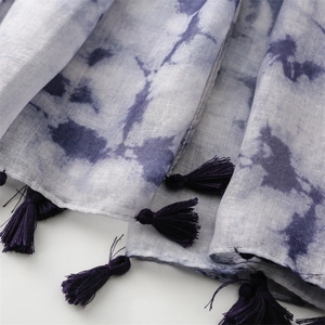 Nahaufnahme der Schal-Textur mit blauer Tinte, dunkelvioletten Quasten und Webstoff