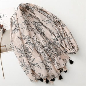 Détail d'une écharpe rose à fleurs avec glands noirs élégants et motifs floraux