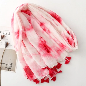 Détail de l'écharpe dégradée rose avec des glands de franges rouges faits à la main