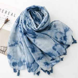 Flachbildaufnahme des blau-weißen Verlaufs-Schals mit Quasten und feiner Batik-Struktur