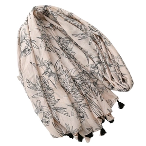 Châle ethnique beige clair avec motif floral, glands noirs et détails dorés brillants
