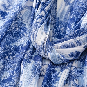 Macro detail of Toile de Jouy silk scarf with blue palm prints and gold glitter accents